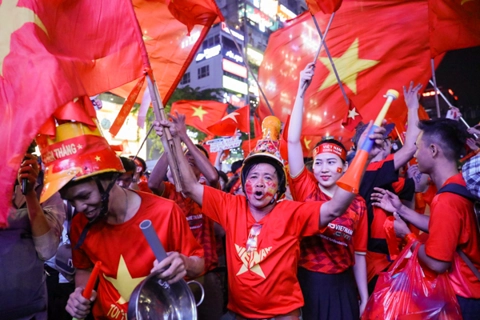 Vietnamese flood streets to celebrate historic football victory