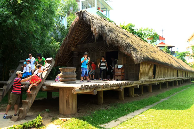Children at Vietnam Museum of Ethnology outdoor traditional houses — Hanoi family attraction