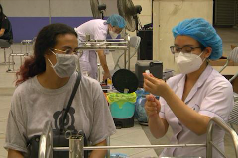 Foreigners in Hanoi get Covid-19 vaccine jab at night