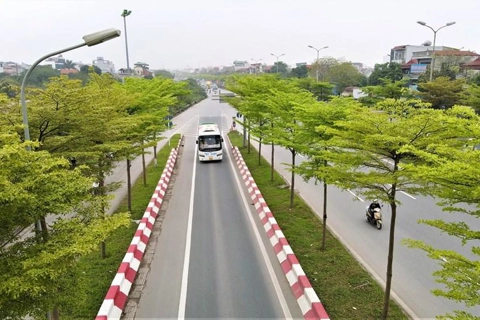 Green trees enhance the beauty of modern intersections in Hanoi